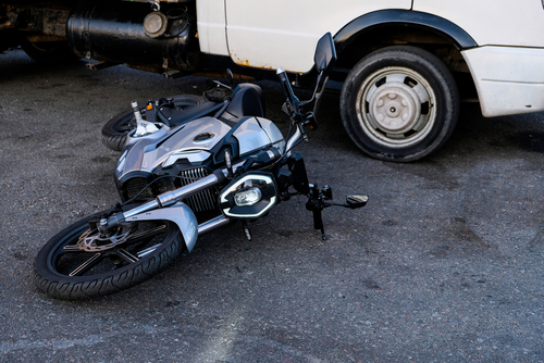 A damaged motorcycle lying beside a van after a collision, illustrating incidents reviewed by a Seattle motorcycle accident lawyer.