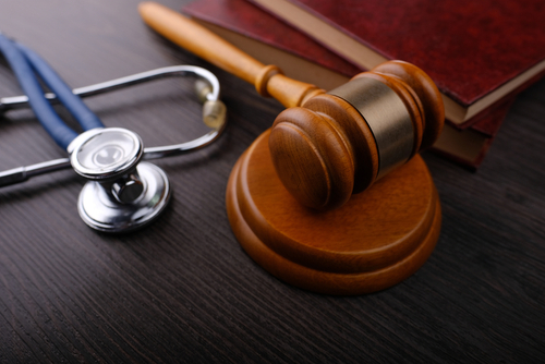 A judge&rsquo;s gavel beside a stethoscope and legal books on a dark desk, symbolizing injury claims handled with the help of a Newcastle personal injury lawyer.