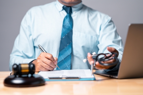 A Fircrest personal injury lawyer reviewing case documents at a desk with a gavel, laptop, and stethoscope, symbolizing legal and medical aspects of injury claims.