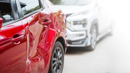 A damaged red car after a rear-end collision, representing claims affected by the Washington car accident statute of limitations.